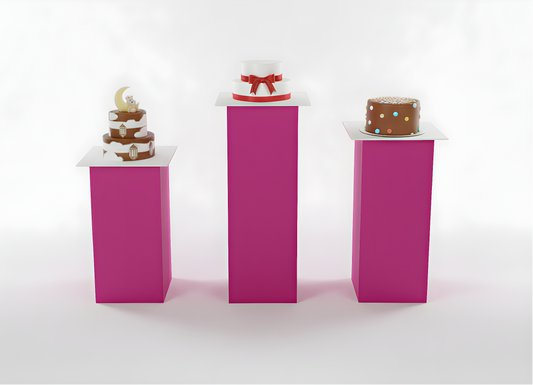 Three small cakes on pink stands against a white background