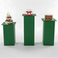 Three small cakes on green stands against a white background