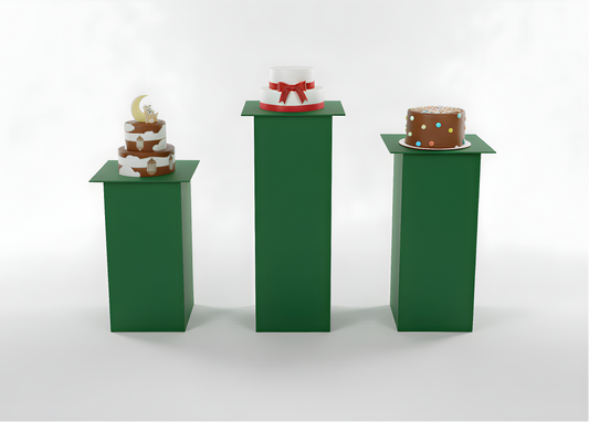 Three small cakes on green stands against a white background