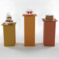 Three small cakes on stands against a white background