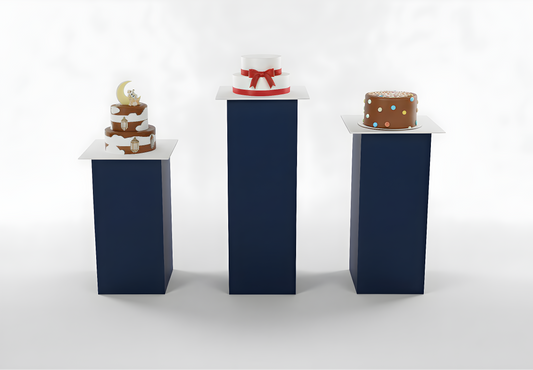 Three small cakes on blue stands against a white background